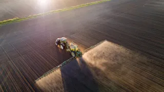 Aerial view of a tractor spraying a field.