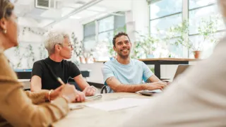 People having a discussion at table in a brightly lit room